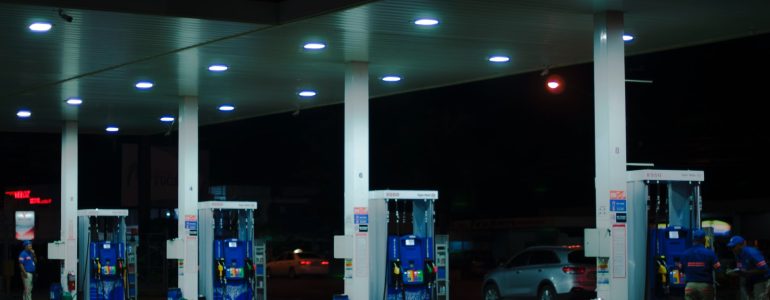 person taking a photo of blue and white gasoline station